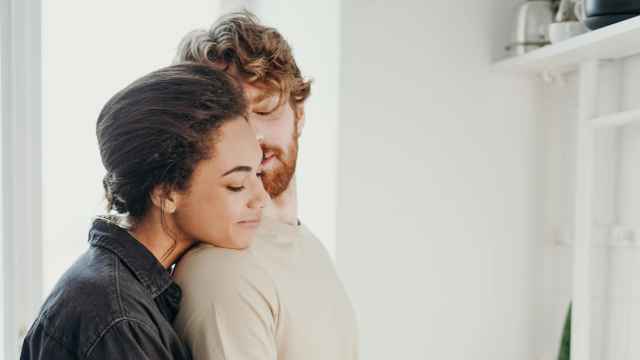 Dos personas se abrazan en la cocina