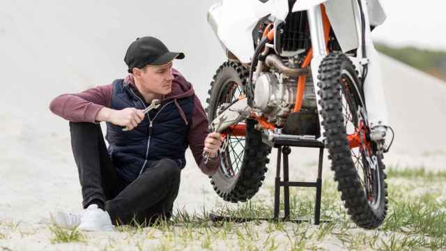 Motorista revisa su moto