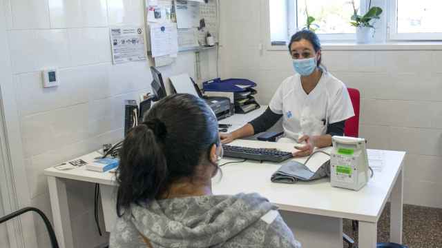Una trabajadora sanitaria atiende a una paciente en el CAP Masdevall el día en el que comienza la campaña de vacunación antigripal en la región, en Figueres, Girona
