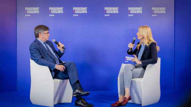 El candidato de Junts+ a las elecciones al Parlament, Carles Puigdemont, con la número dos de la lista, Anna Navarro, ante un fondo del nuevo color corporativo