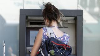 Una joven saca dinero de un cajero automático