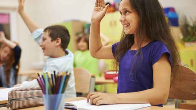 Alumnos levantan la mano en el aula para poder intervenir en la clase