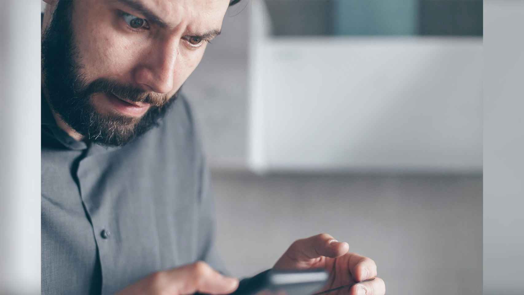 Persona mira el móvil extrañada