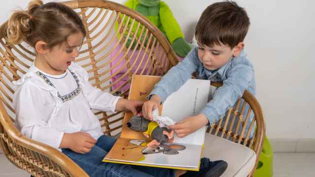 Dos niños mirando las páginas de un cuento