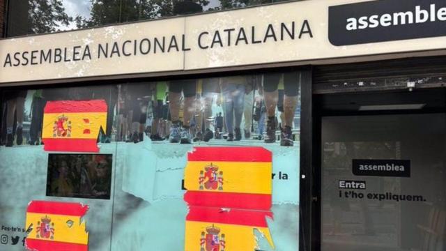 La sede de la ANC amanece con banderas españolas pegadas en los cristales