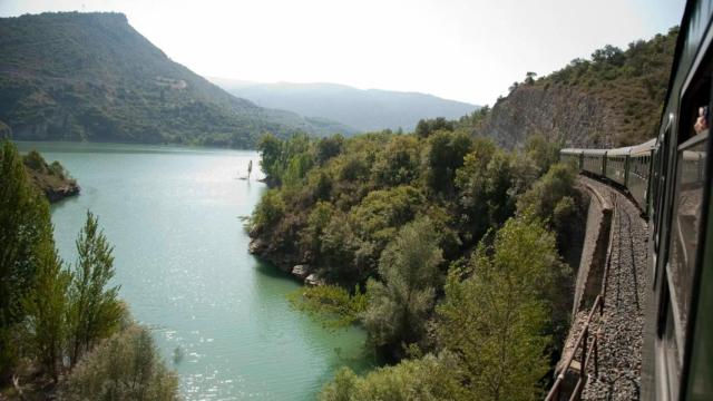 Un tren histórico pasando por un lago