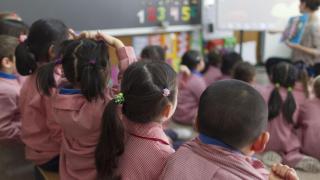 Una profesora en un aula con alumnos de primaria