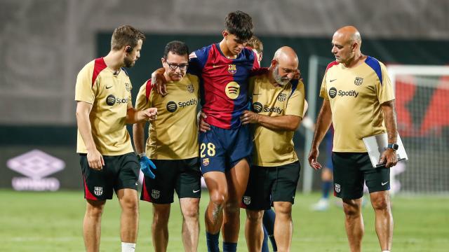 Marc Bernal se marcha lesionado de Vallecas, apoyado en el hombro del doctor Carles Miñarro (izquierda)