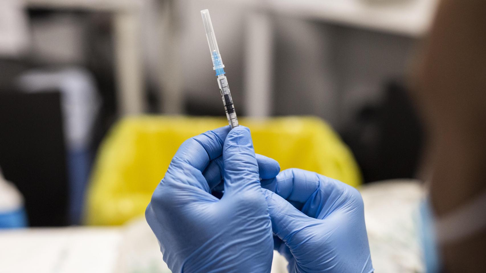 Un sanitario sostiene una dosis de vacuna