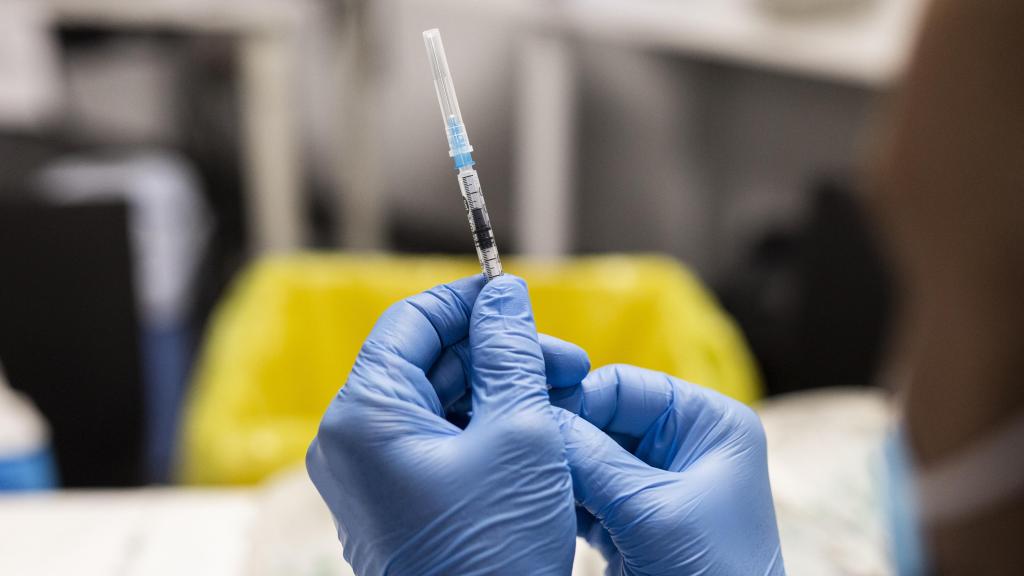 Un sanitario sostiene una dosis de vacuna