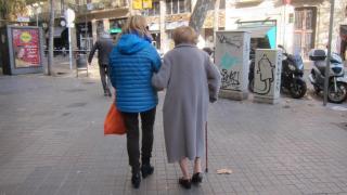 Una mujer paseando junto a su madre
