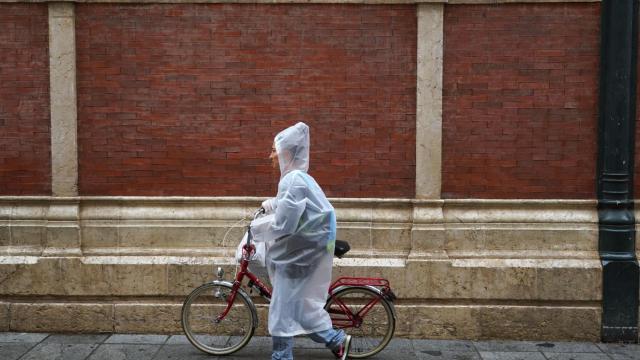 Imagen de una mujer caminando bajo la lluvia