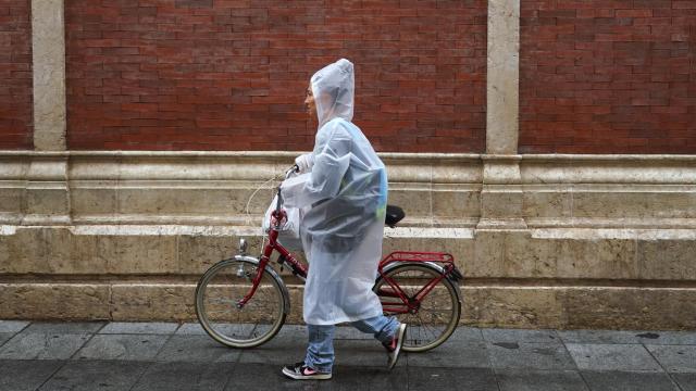 Imagen de una mujer caminando bajo la lluvia