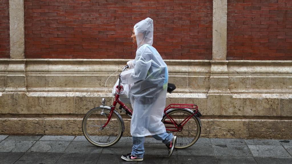 Imagen de una mujer caminando bajo la lluvia