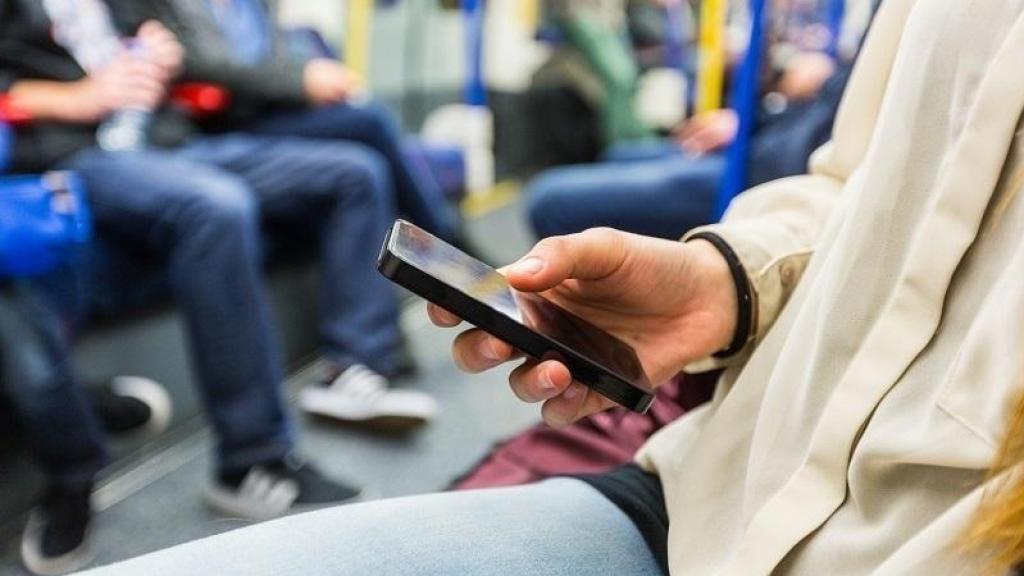 Una dona usant xarxes socials en el transport públic