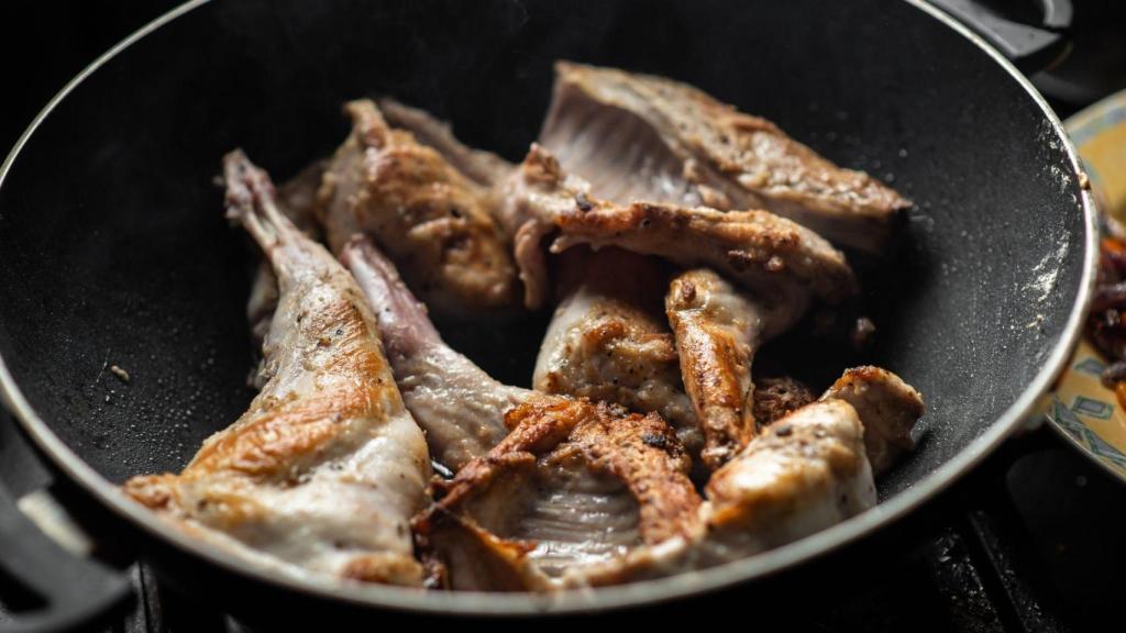 Carne de conejo cocinándose en una olla