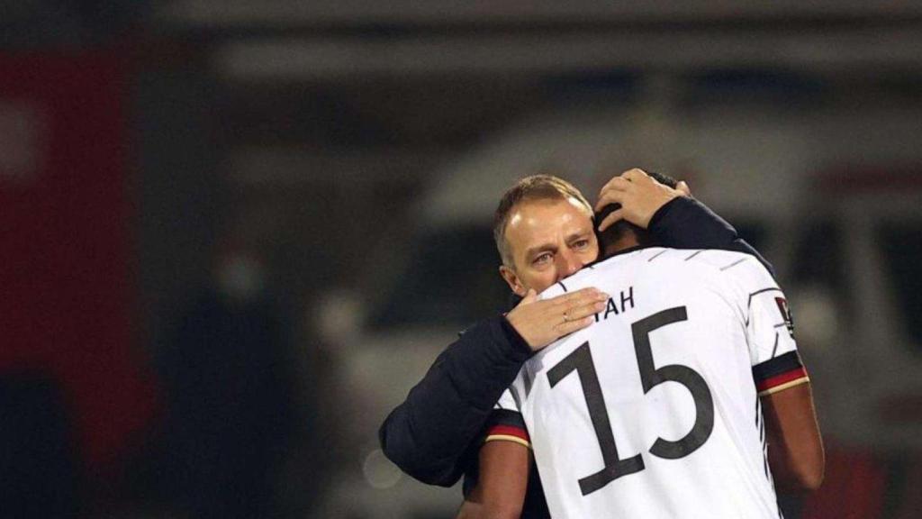 Hansi Flick abraça a Jonathan Tah com a seleccionador d'Alemanya