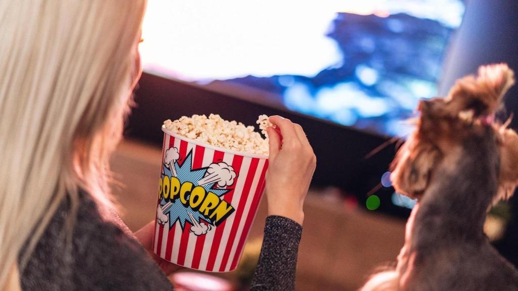 Mujer come palomitas frente al televisor