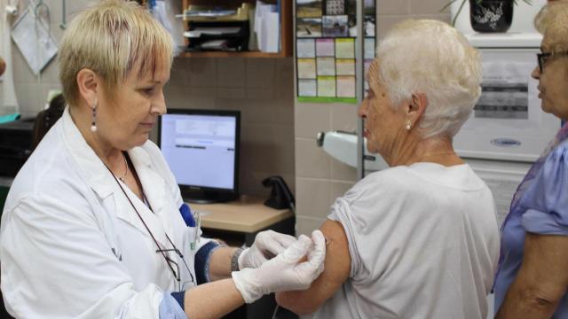 Una mujer recibe la vacuna de la gripe en Cataluña