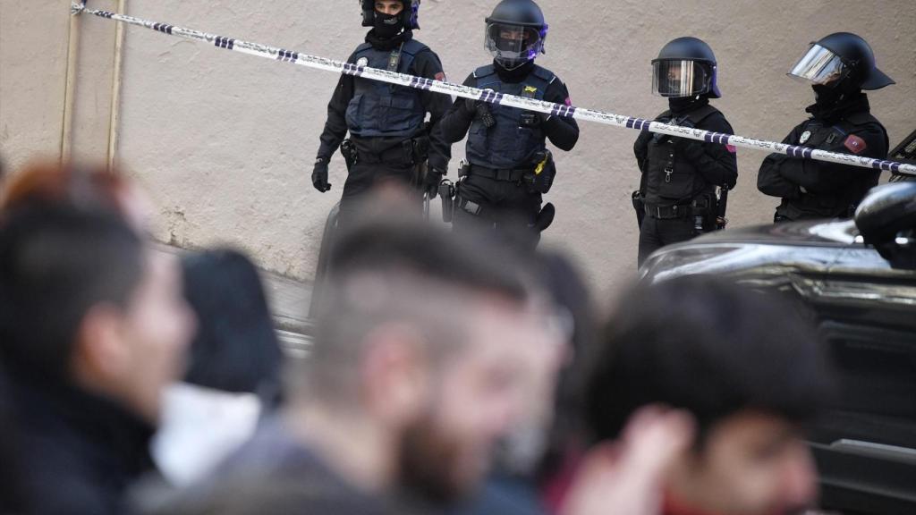 Miembros de la Policía Nacional frente a los vecinos concentrados en protesta por el desalojo de un centro social okupado
