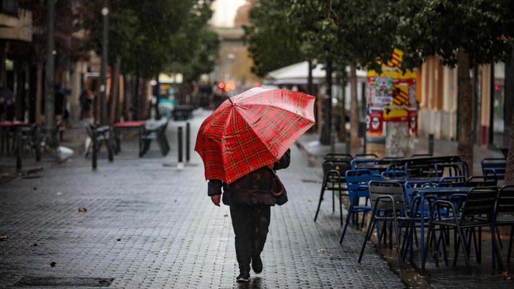 Una persona se protege de la lluvia