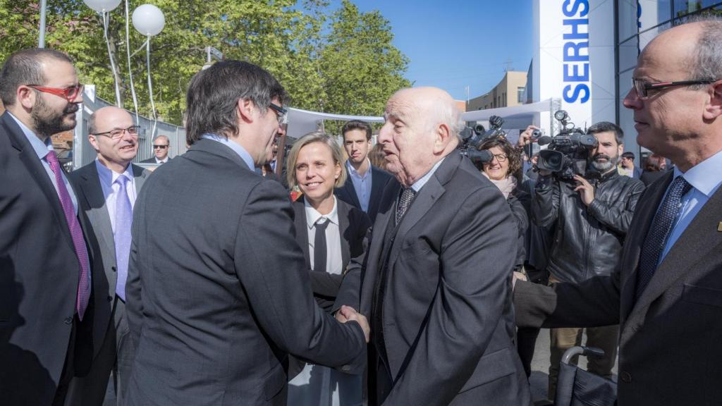 El expresidente de Cataluña Carles Puigdemont (i) saluda al fundador de Serhs Ramon Bagó