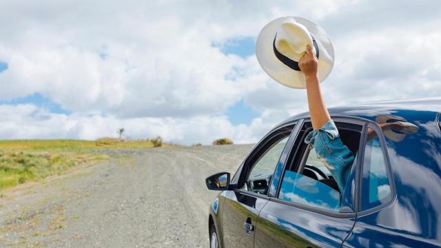 Saludo desde un coche con un sombrero
