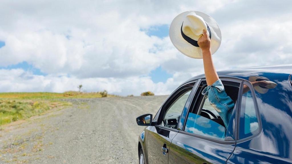 Saludo desde un coche con un sombrero