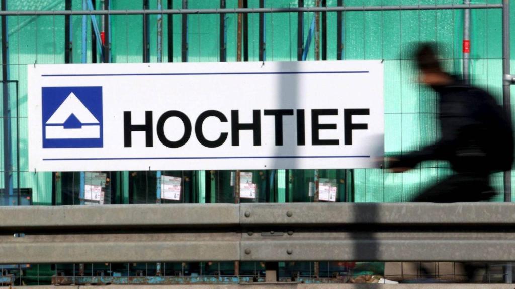 Un ciudadano, ante un rótulo corporativo de Hochtief