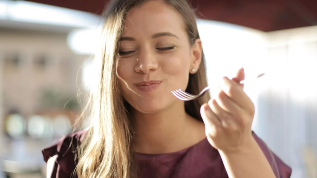 Una mujer prueba un plato de comida
