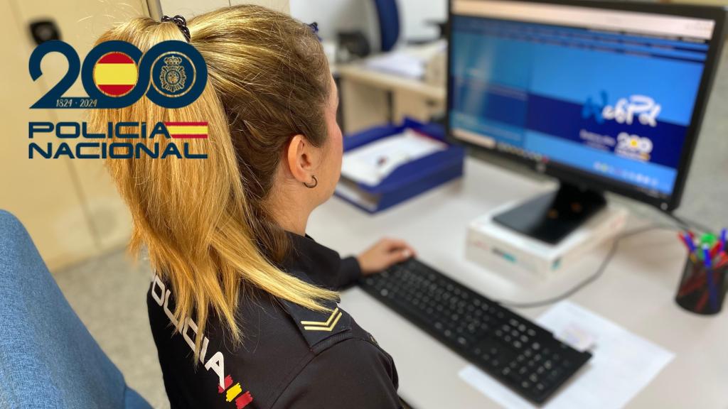 Una agente de policía revisa documentación en un ordenador