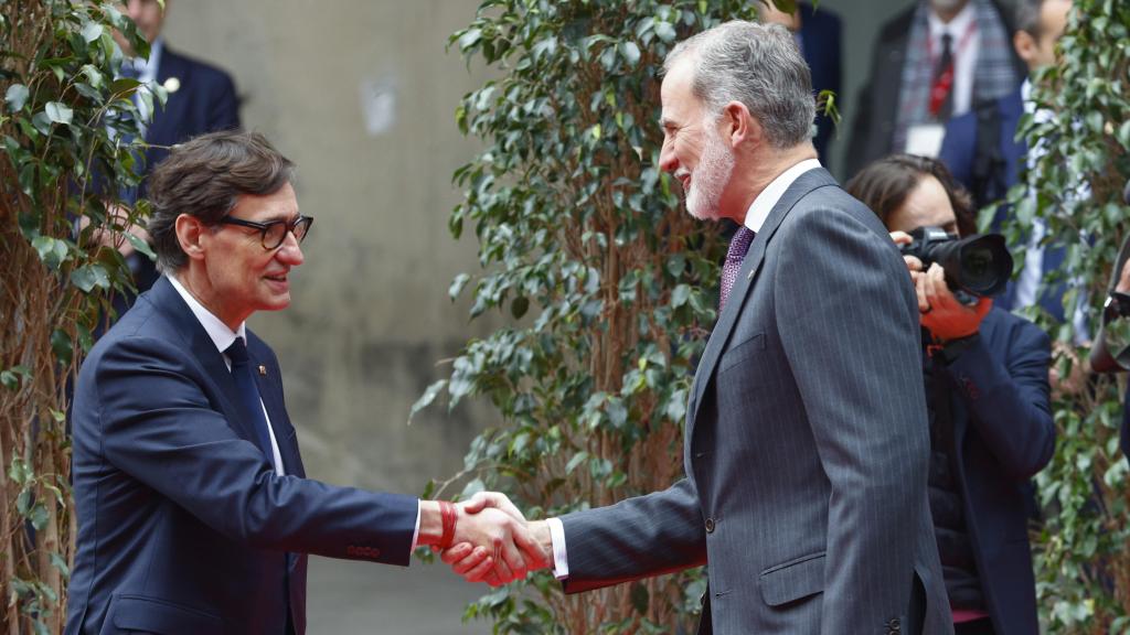 El rey Felipe VI (d) saluda al presidente de la Generalitat, Salvador Illa (i) durante la inauguración del MWC 2025