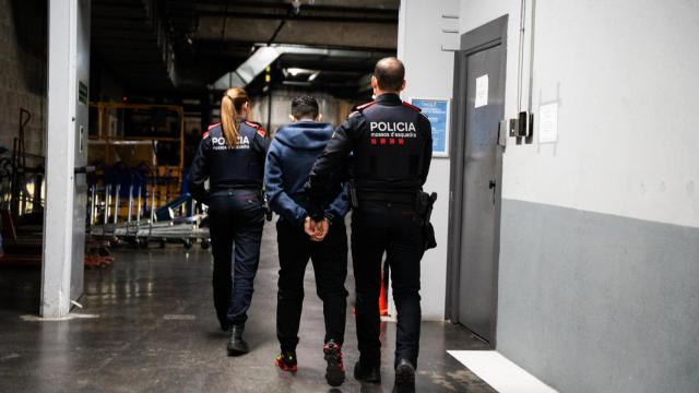 Mossos d'Esquadra trasladando a un detenido por robo en L'Hospitalet de Llobregat