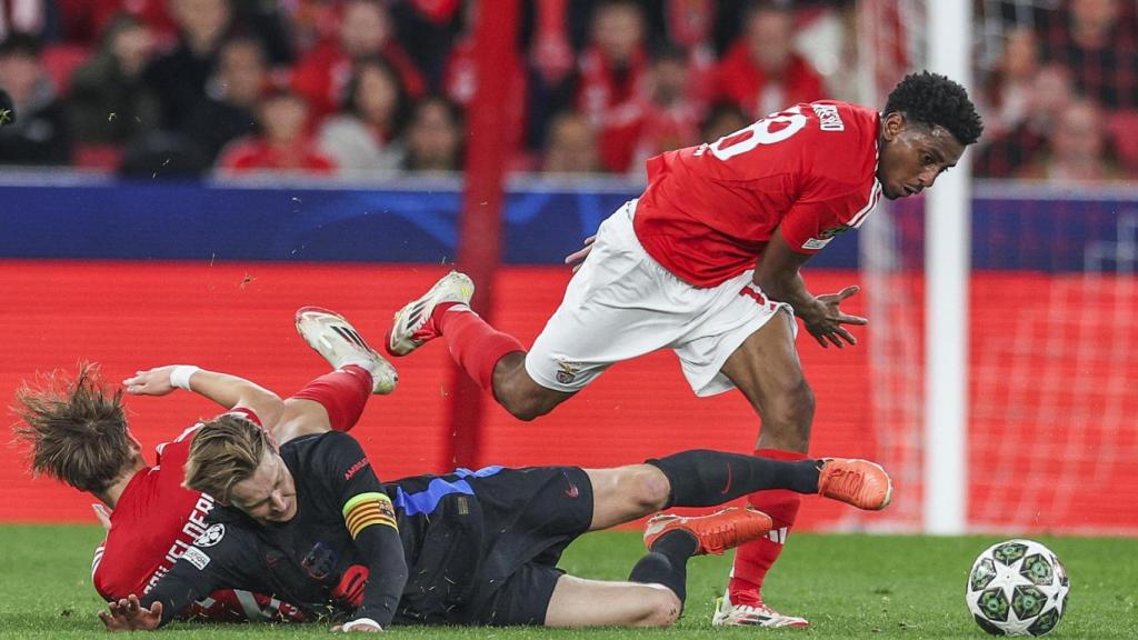 Frenkie de Jong pugna por el balón con dos jugadores del Benfica