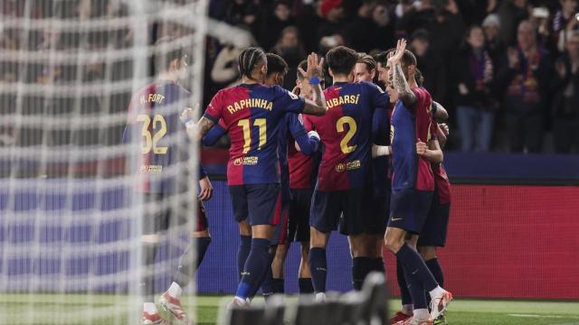 Los jugadores del Barça celebran un gol, con la red de la portería en primer plano