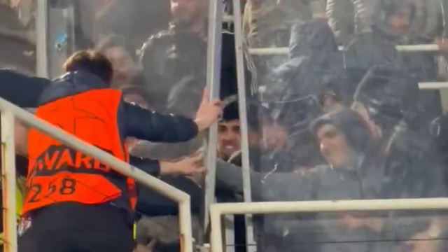 Un 'steward' del Barça lucha por contener a la afición del Lisboa en su sector de Montjuïc