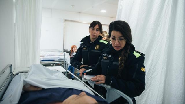 Dos agentes de la Guardia Urbana de Barcelona, atendiendo a una persona herida