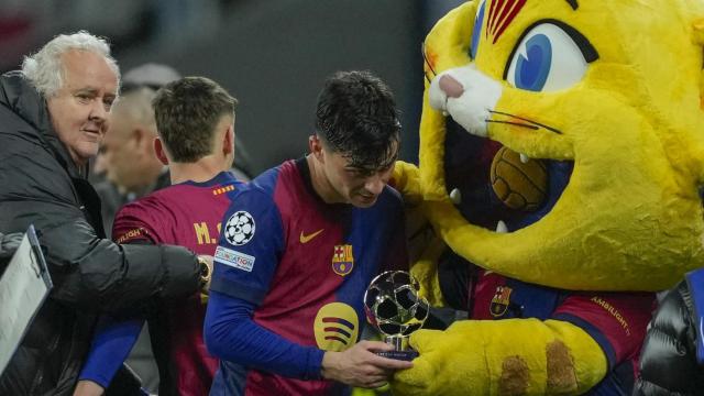 Pedri recibe el trofeo MVP del Barça-Benfica de manos de la mascota Cat