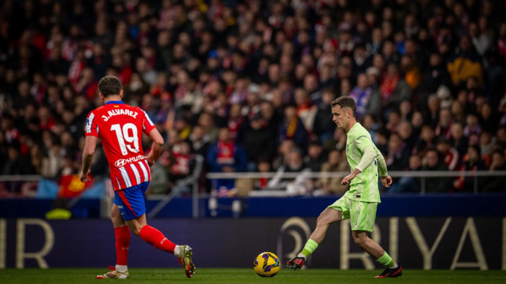 Marc Casadó da un pase durante el Atlético de Madrid-Barça, ante la presión de Julián Álvarez
