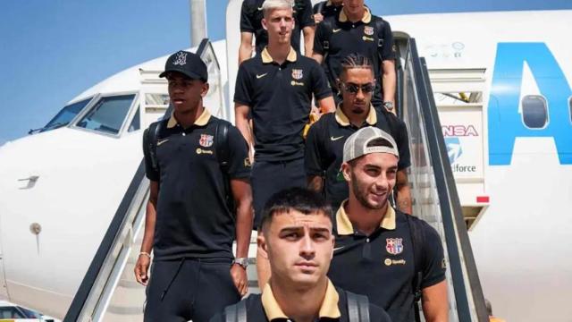Lamine Yamal, Pedri y Raphinha bajan del avión, junto con otros compañeros, en un desplazamiento del Barça