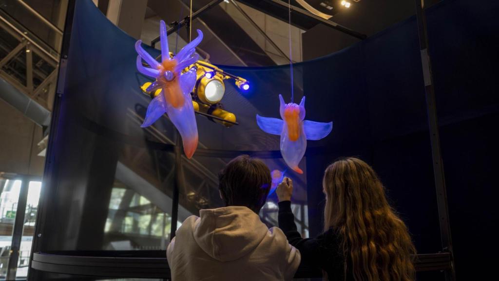 Dos visitantes observan los seres de ficción a la entrada de la exposición