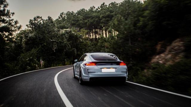 Coche deportivo por una carretera entre bosques