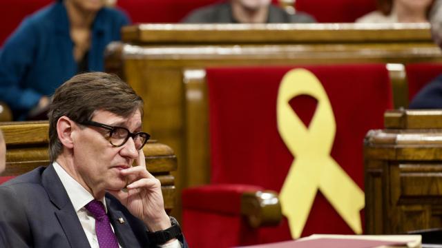 El presidente de la Generalitat, Salvador Illa, y un lazo amarillo de fondo en un escaño de Junts, vacío