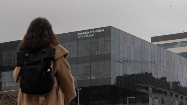 Una mujer pasa por delante de la sede de la Agencia Tributaria de Cataluña, a 21 de marzo de 2025, en Barcelona, Cataluña (España).