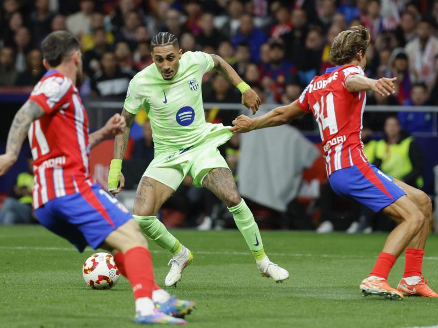 Marcos Llorente agarra del pantalón a Raphinha durante el Atlético de Madrid-Barça