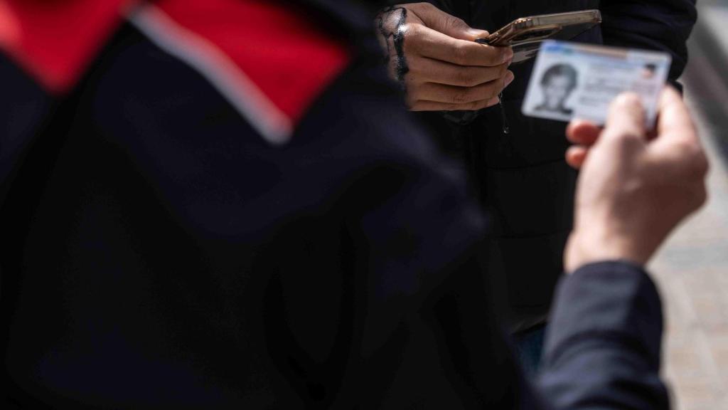 Un agente de los Mossos comprobando un documento de identidad