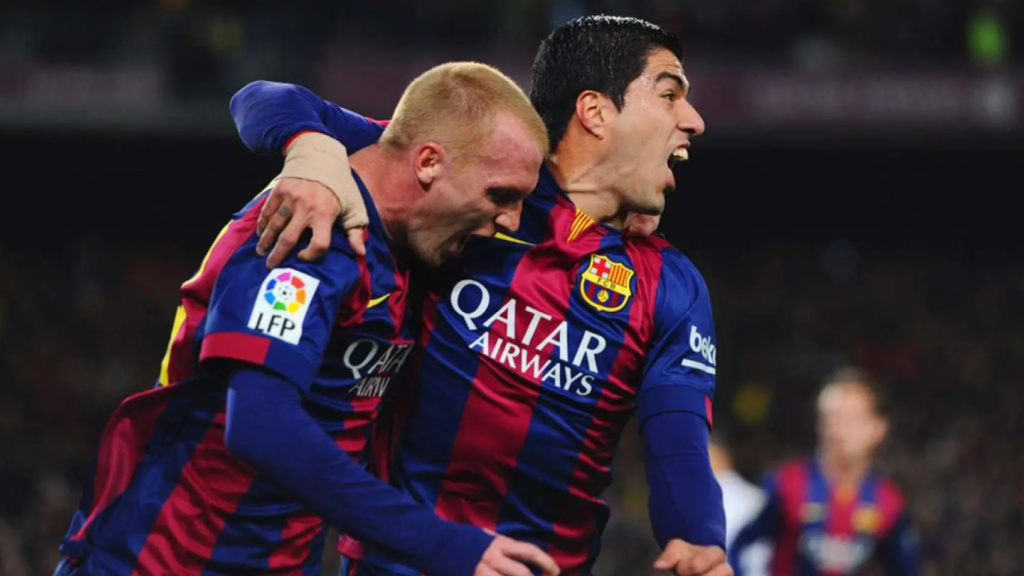 Jeremy Mathieu celebra un gol del Barça con Luis Suárez en 2015