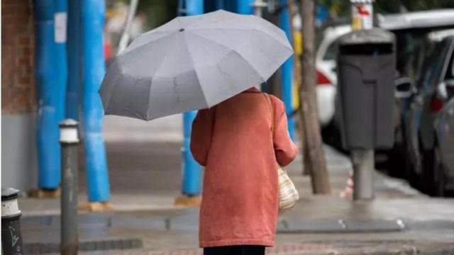 Una mujer se protege de la lluvia