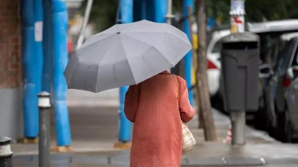 Una mujer se protege de la lluvia