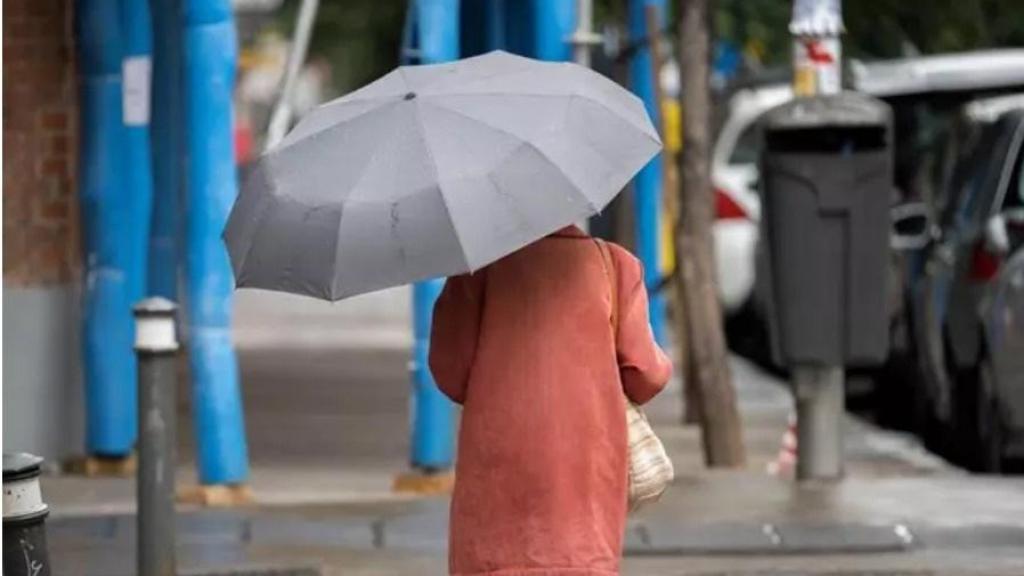 Una mujer se protege de la lluvia